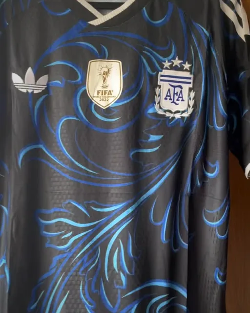 Camisa preta da Argentina com arabescos azuis e o escudo da AFA